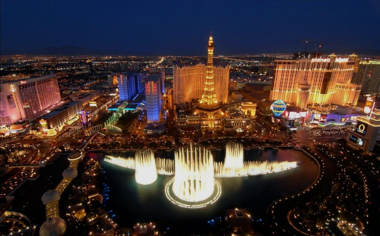 Las Vegas Strip à noite, com a Torre Eiffel do Paris Las Vegas e as fontes do Bellagio